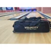 Velocity 3 Ball Triple Tote Black Gold bowling bag beside the lanes, gold trim and wheels visible